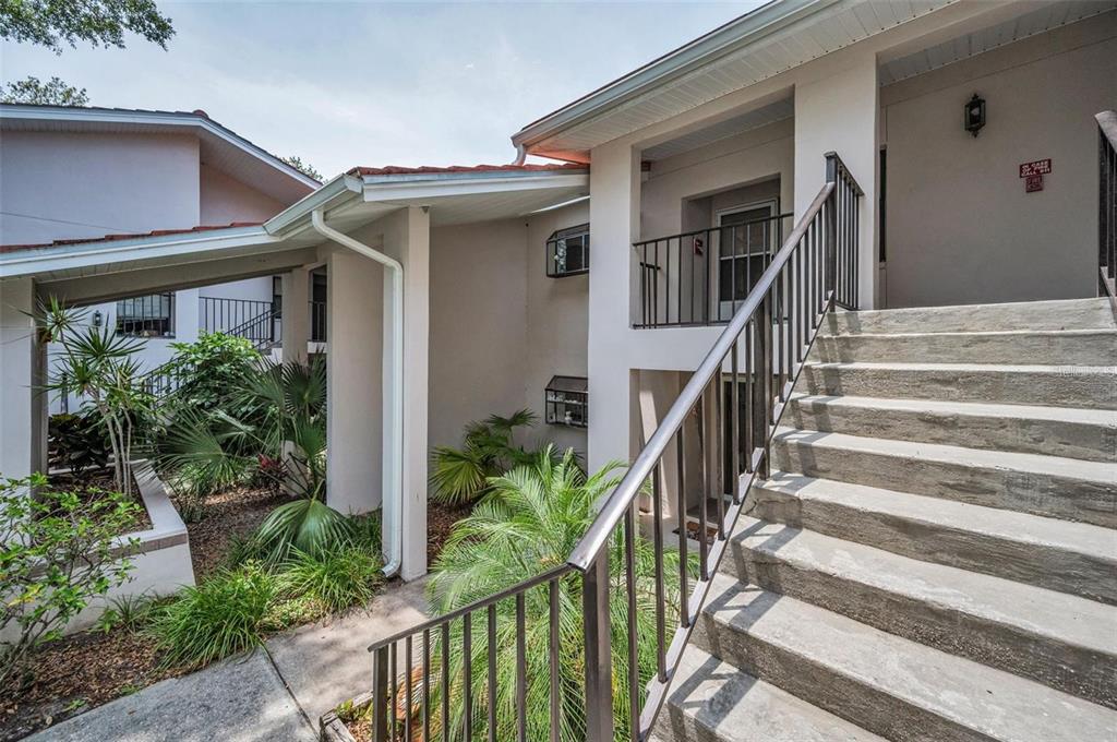 An outdoor staircase leads to a second-story balcony of a multi-level residential building — 300 S FLORIDA AVENUE UNIT 200J, TARPON SPRINGS, FL