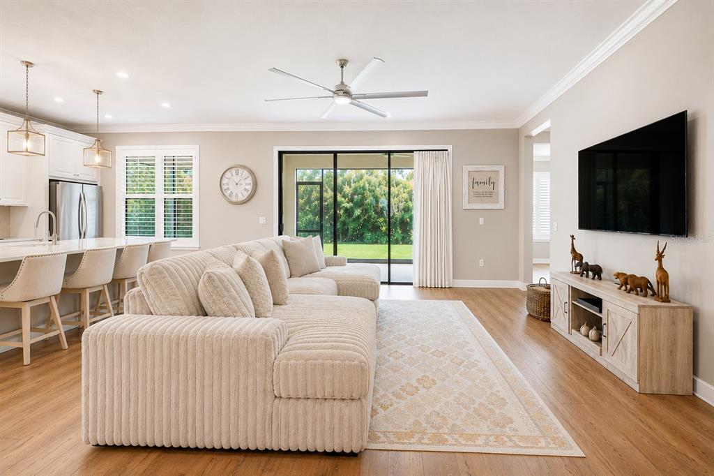 A dining room features a wooden table with six upholstered chairs under a rectangular chandelier — 3870 BOWFIN TRAIL, KISSIMMEE, FL