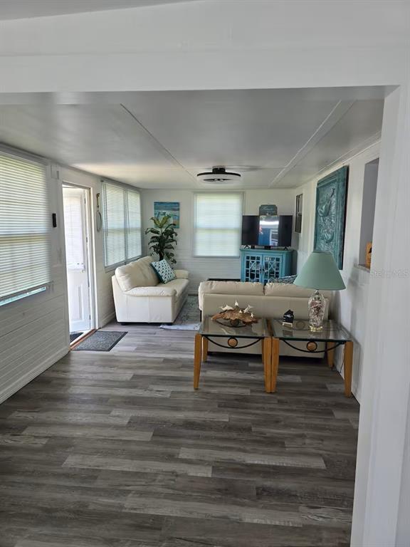 A living room features light-colored sofas, wood-look flooring, and a blue media console — 5247 ALPACA DRIVE, WEEKI WACHEE, FL