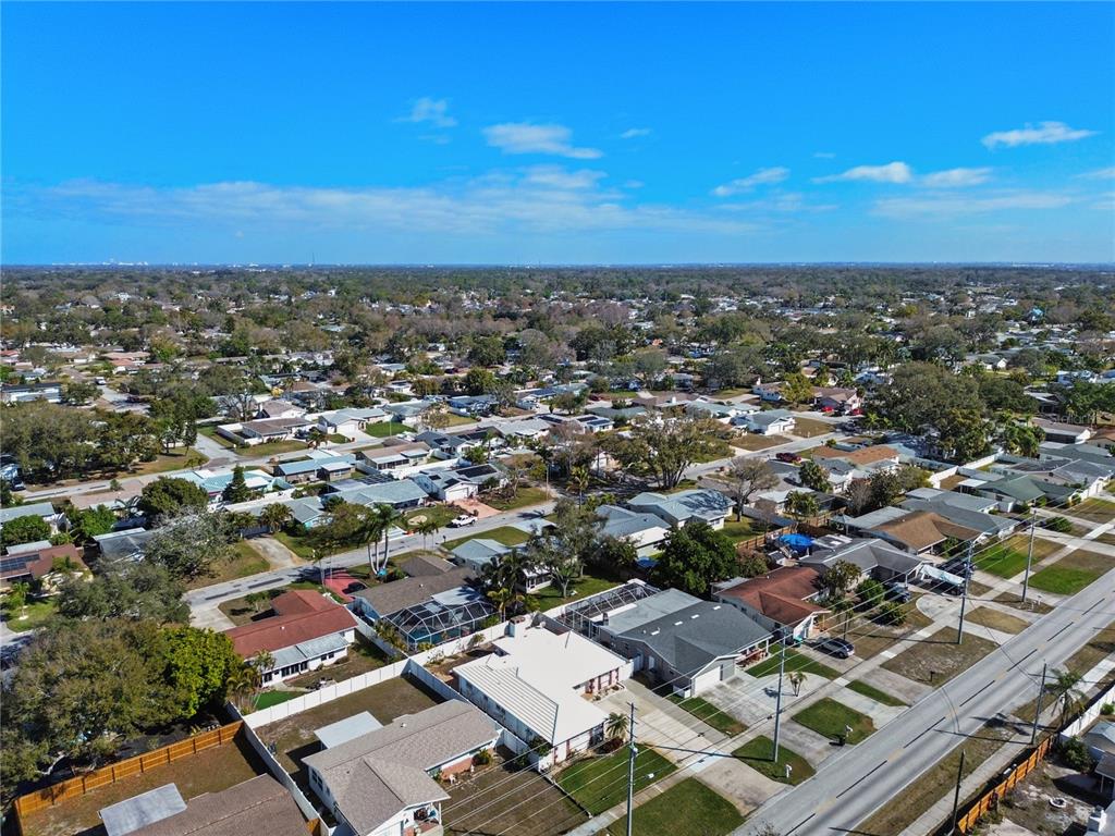 An aerial view shows a residential neighborhood with single-family homes and tree-lined streets — 13565 86TH AVENUE, SEMINOLE, FL
