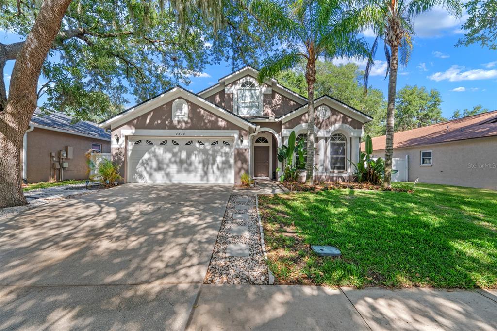 A single-story house with a two-car garage, a concrete driveway, and a front lawn — 4814 PORTOBELLO CIRCLE, VALRICO, FL