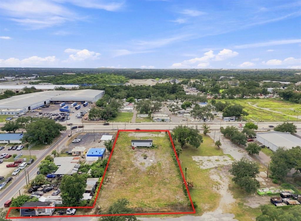 An aerial view shows a rectangular vacant lot outlined in red with a small structure — 4946 E HILLSBOROUGH AVENUE, TAMPA, FL