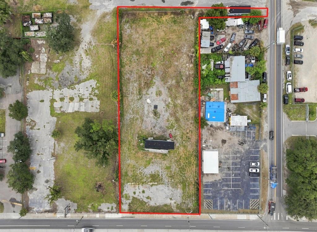 An aerial view shows a rectangular vacant lot outlined in red next to a parking lot — 4946 E HILLSBOROUGH AVENUE, TAMPA, FL