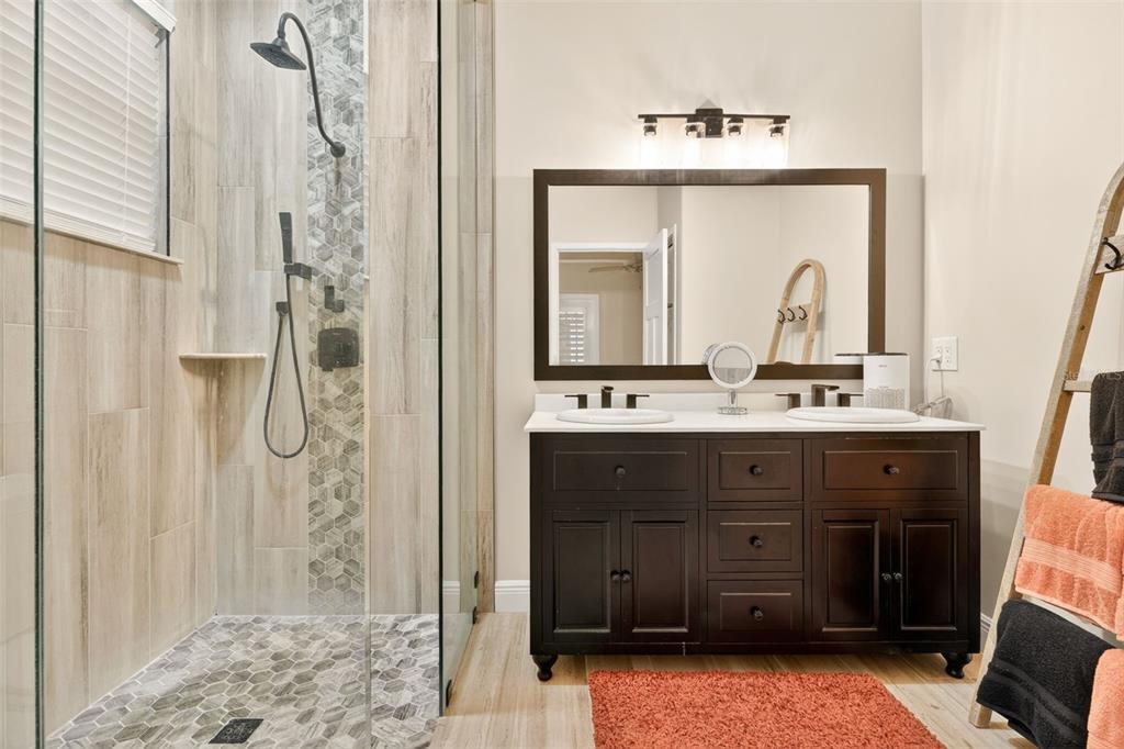 A bathroom features a glass-enclosed shower with tiled walls, a double-sink vanity, and a towel ladder — 842 W SILVER MEADOW LOOP, HERNANDO, FL