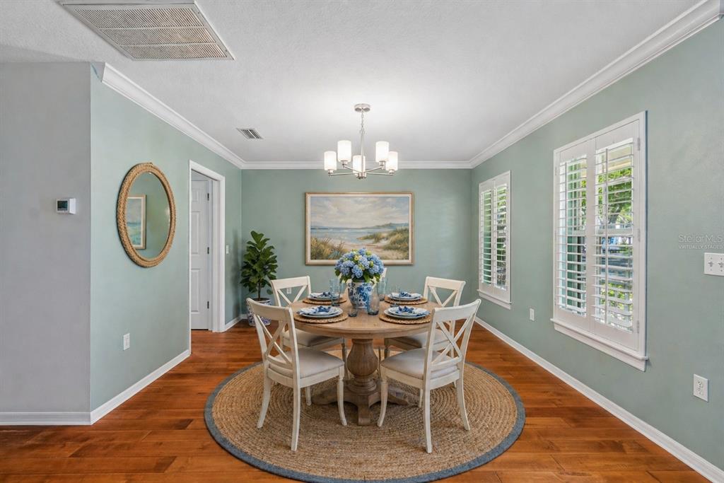 A cozy reading nook features a cream armchair, ottoman, built-in shelving, and blue-green walls — 6414 23RD AVE DR W, BRADENTON, FL