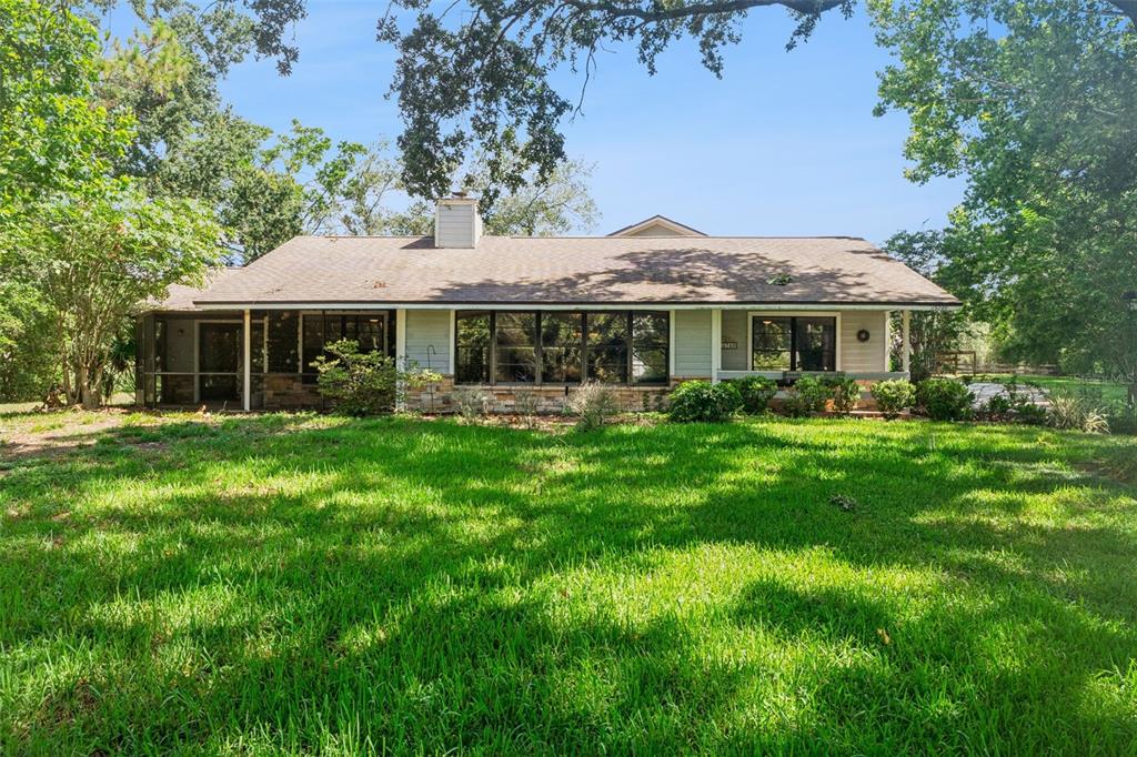 A two-story house with light siding, multiple garage bays, and a large concrete driveway — 15749 ARABIAN WAY, MONTVERDE, FL