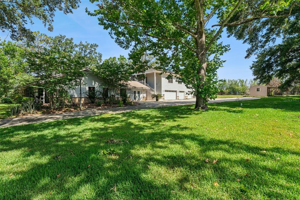 A two-story house with light siding and a large lawn under mature trees — 15749 ARABIAN WAY, MONTVERDE, FL