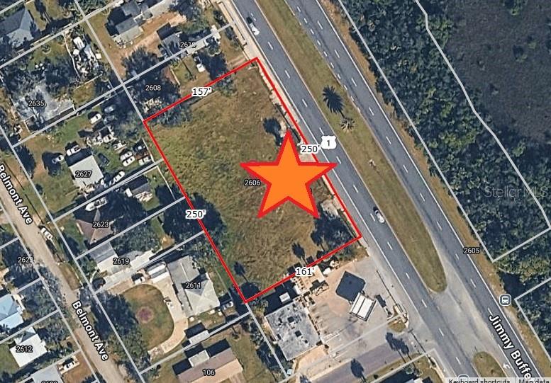 This aerial map shows a vacant rectangular lot outlined in red next to a highway — 2606 N DIXIE FREEWAY, NEW SMYRNA BEACH, FL