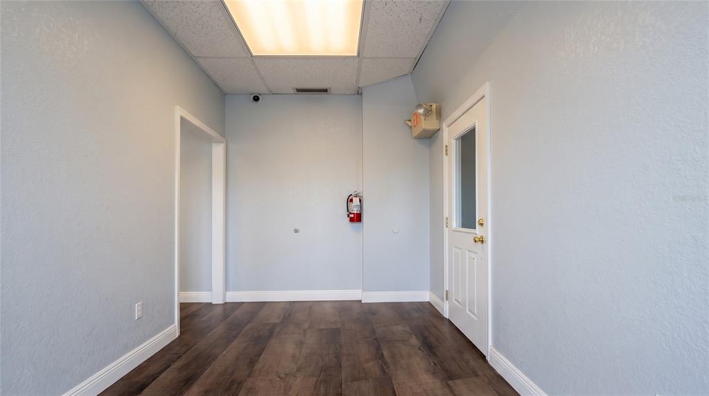 A breakroom features a kitchenette with white cabinets, a dark blue wall, and seating area — 223 N COMMONWEALTH AVENUE SW, POLK CITY, FL