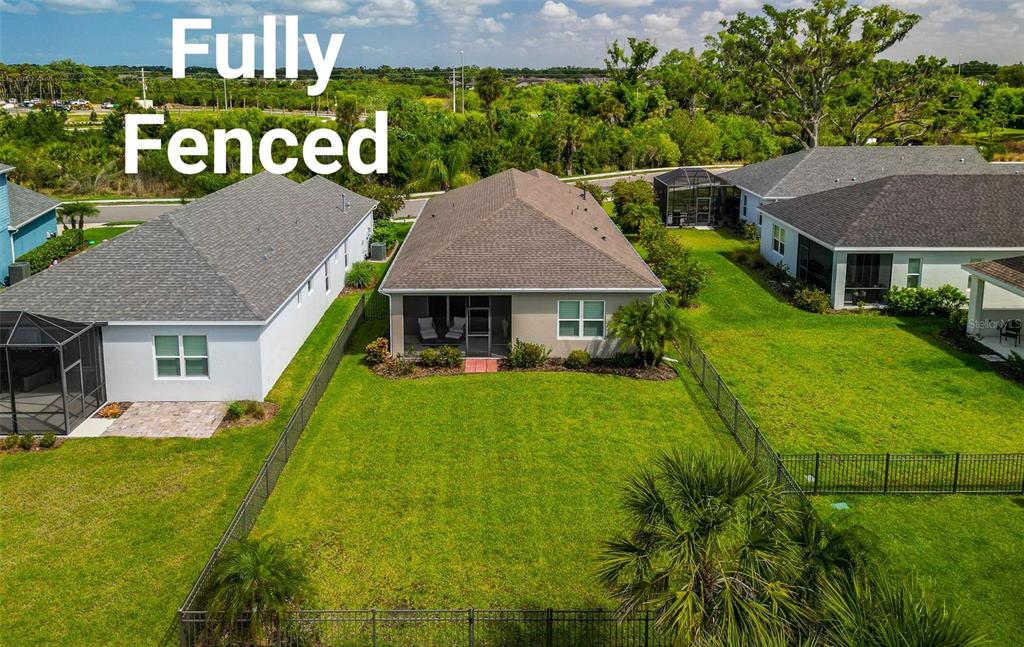 An aerial view shows the backyard of a house with a fenced lawn and patio — 4815 DEEP CREEK TERRACE, PARRISH, FL