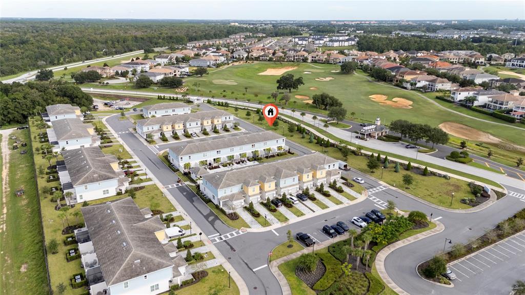 An aerial view shows a residential complex of townhomes situated next to a golf course — 7900 DRAW STREET, REUNION, FL