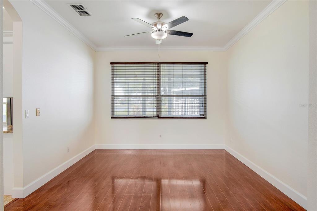 A living room with hardwood floors, a wooden staircase, and a ceiling fan — 12661 ENCLAVE DRIVE, ORLANDO, FL