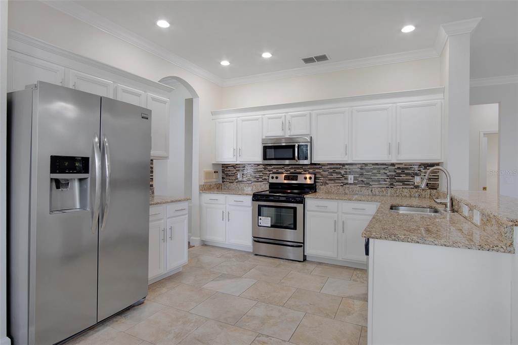 An empty dining room features hardwood floors, a ceiling fan, and a large window — 12661 ENCLAVE DRIVE, ORLANDO, FL