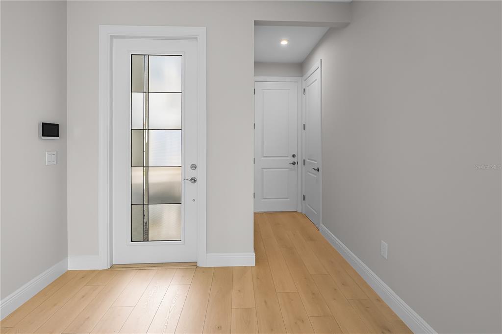 An entryway features light wood flooring, a white front door with glass panels, and two doors — 14366 HAMMOCK OAK STREET, PARRISH, FL