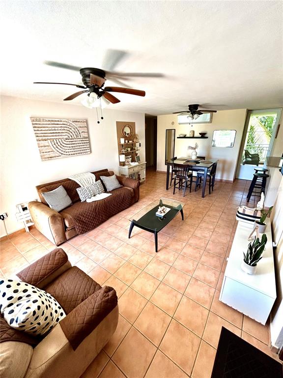 A living and dining room features tile floors, a brown sofa, and two ceiling fans — 187 SECTOR EL MARTILLO, BARRIO MEDIANIA ALTA UNIT F-304, LOIZA, PR