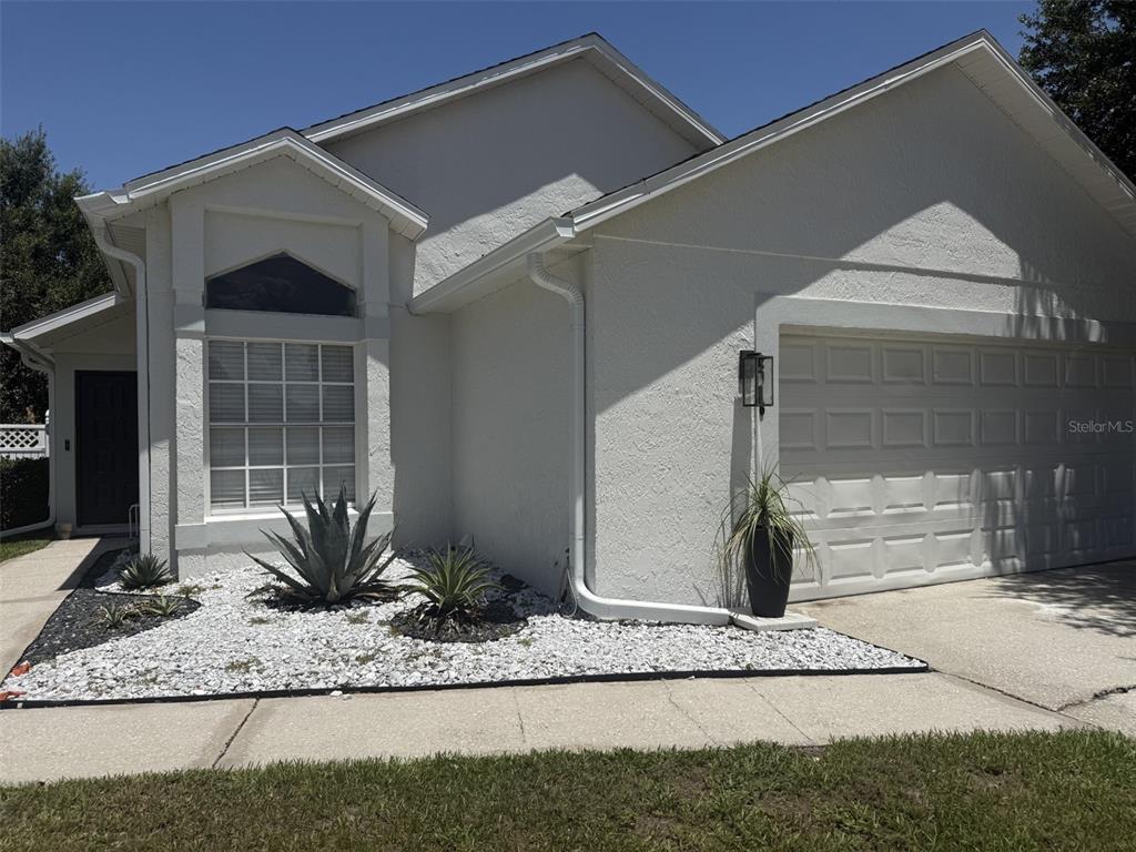 A single-story white house with a two-car garage and a small front garden — 2916 CANOE CIRCLE, ST CLOUD, FL