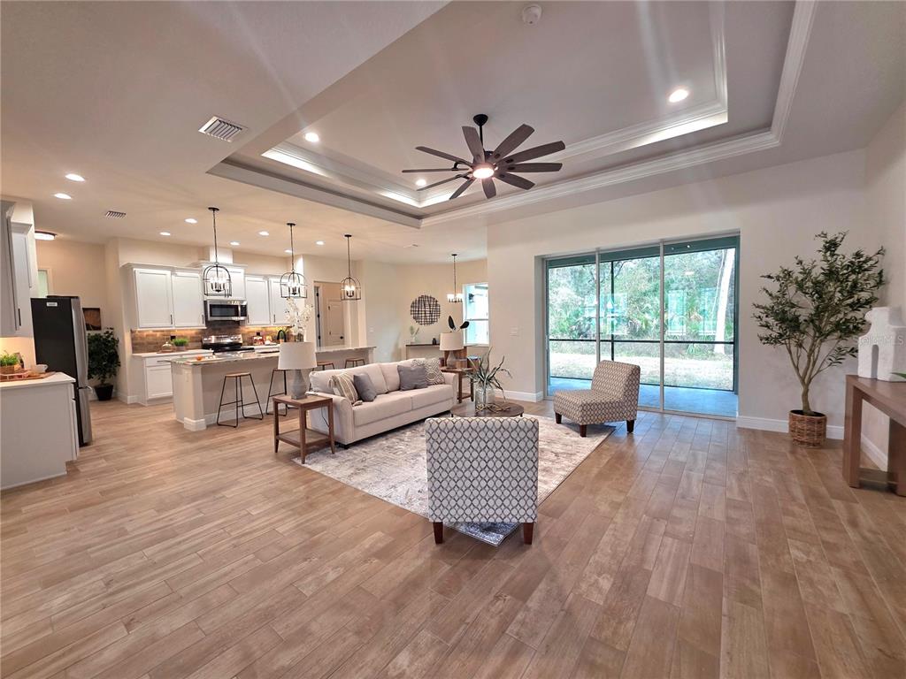 A foyer with wood-look tile flooring leads into a living area with a ceiling fan — 13444 REPUBLICAN WAY, BROOKSVILLE, FL