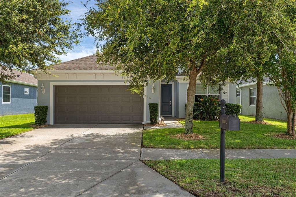 A single-story house with a gray exterior, a two-car garage, and a front lawn — 14912 POTTERTON CIRCLE, HUDSON, FL