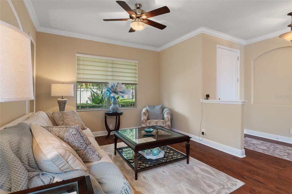 A living room features a sofa, glass-topped coffee table, ceiling fan, and hardwood flooring — 14912 POTTERTON CIRCLE, HUDSON, FL
