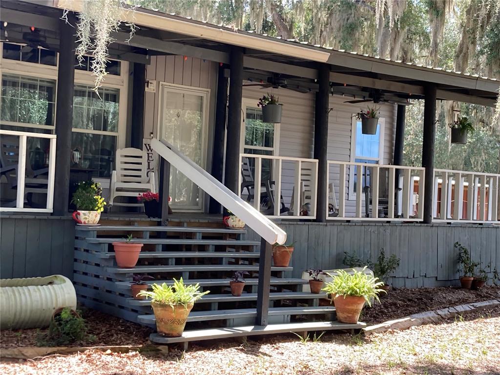 A single-story house with a covered porch sits on a grassy lot with trees — 601 PURVIS ROAD, SEVILLE, FL