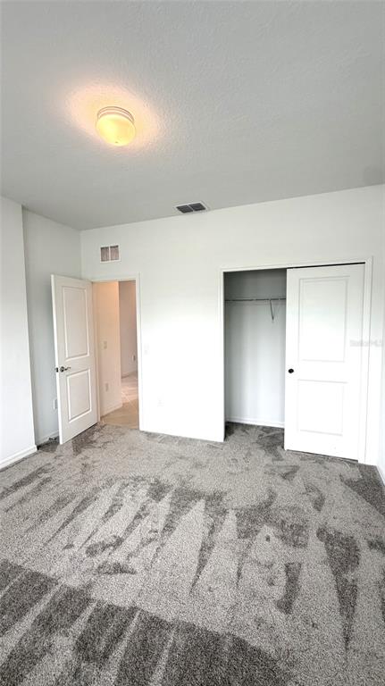 A bedroom with gray carpet, white walls, a ceiling light, and two white doors — 957 SILVERLAKE BOULEVARD, LAKE ALFRED, FL