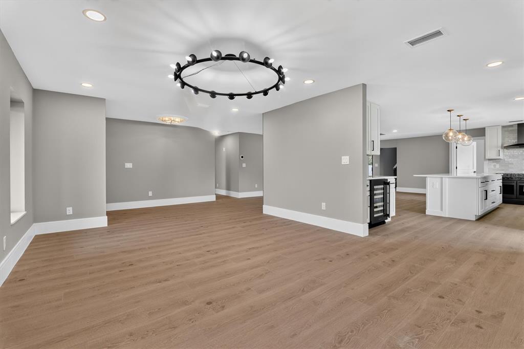 A modern, white single-story house with a dark roof, garage, and paved driveway — 2491 LAUDER DRIVE, MAITLAND, FL
