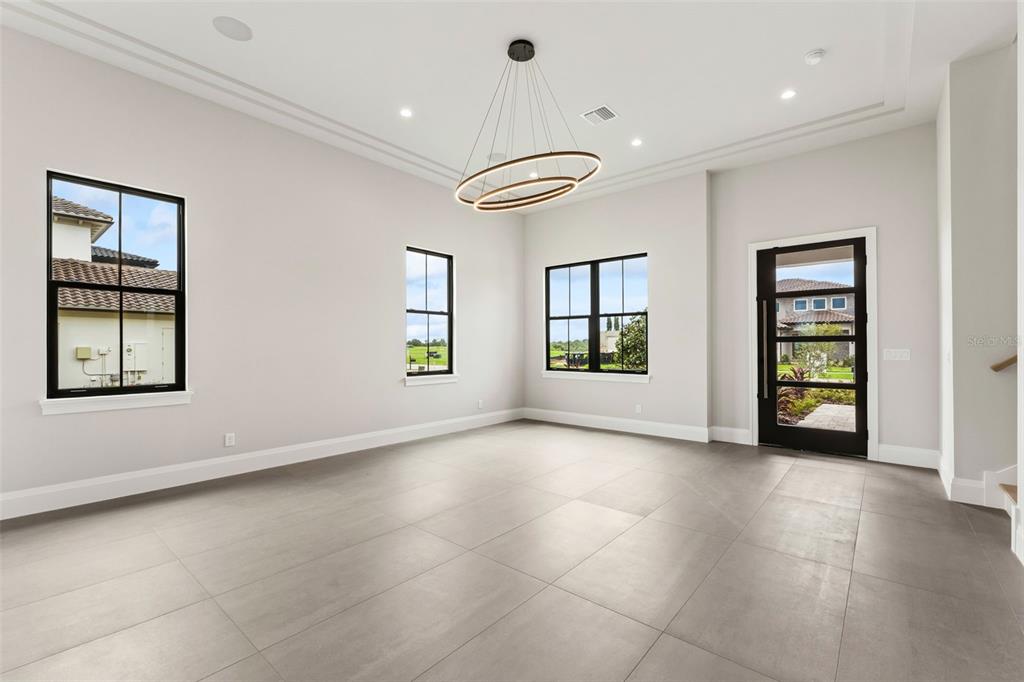 A digital rendering of a two-story house with a gray stone facade and two-car garage — 15825 VETTA DRIVE, BELLA COLLINA, FL
