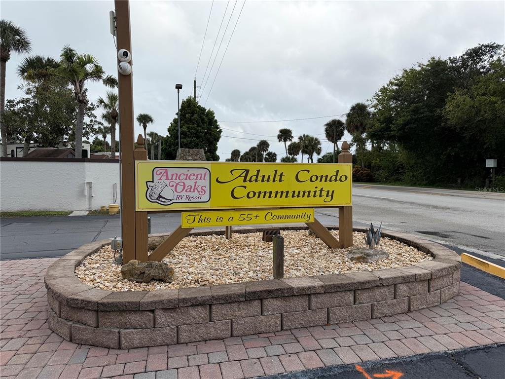 A yellow sign for Ancient Oaks RV Resort and 55+ Adult Condo Community stands outdoors — 6521 SE 55TH STREET, OKEECHOBEE, FL