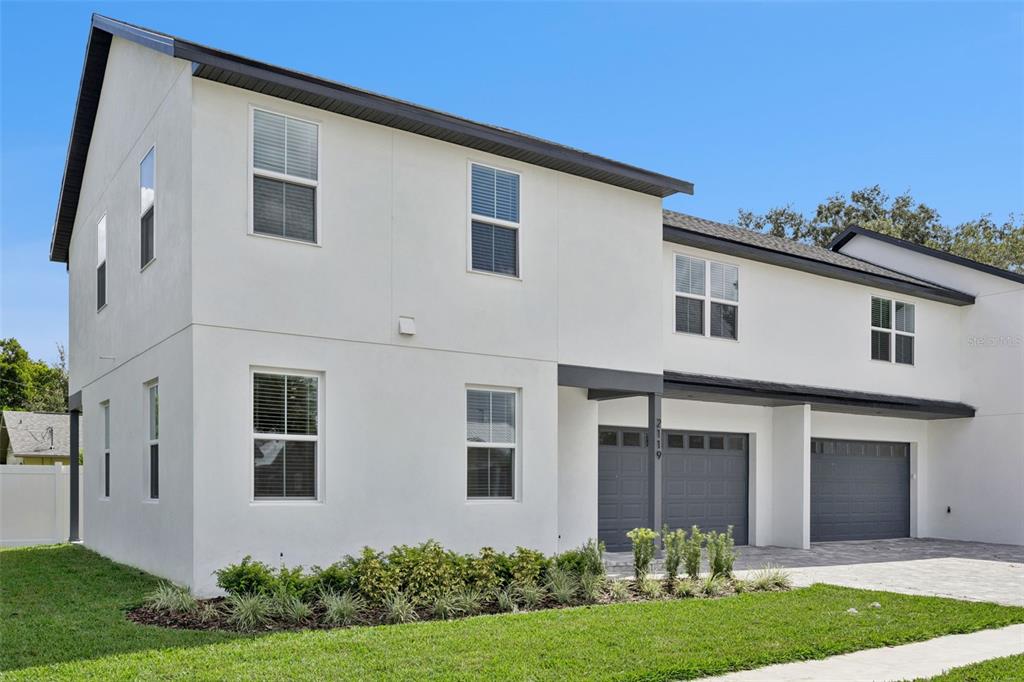 A living room features a white shiplap fireplace, wood-look flooring, and two built-in cabinets — 2119 W LUCERNE TERRACE, ORLANDO, FL