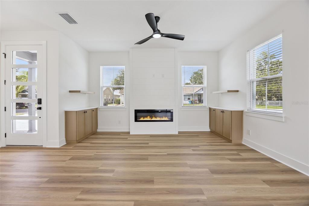 A living room features light wood floors, a central fireplace, and built-in wooden cabinets — 2119 W LUCERNE TERRACE, ORLANDO, FL