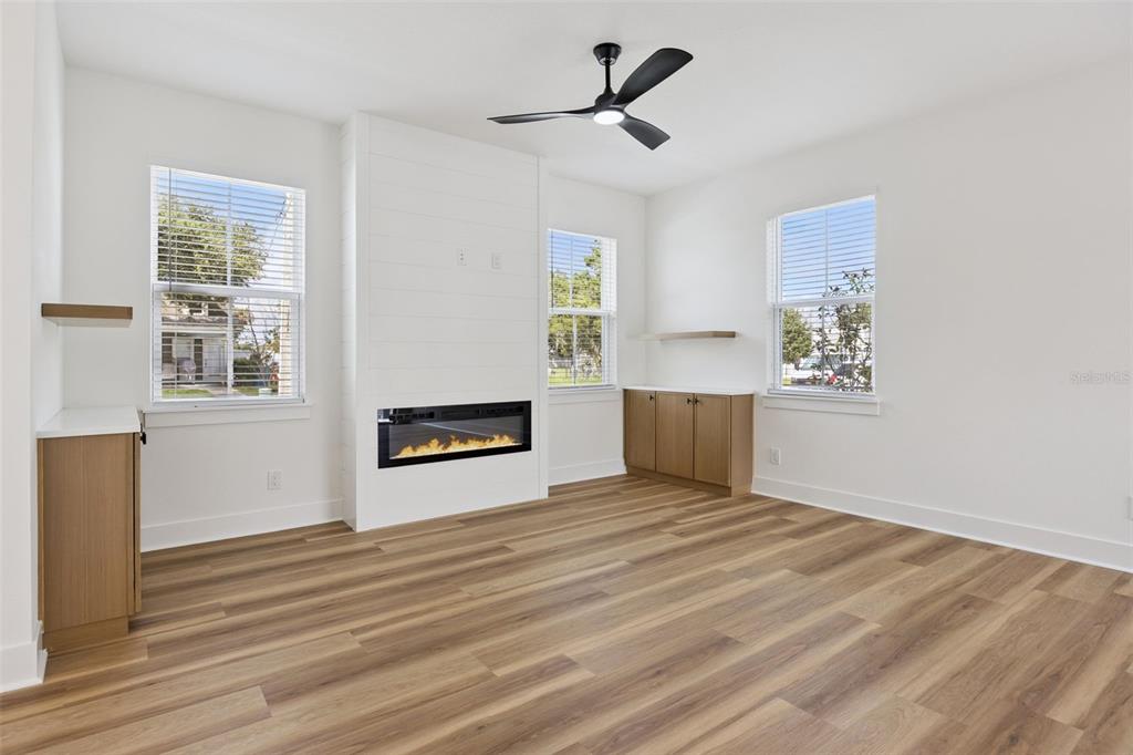 A living room features light wood flooring, a white shiplap fireplace, and built-in wooden cabinets — 2119 W LUCERNE TERRACE, ORLANDO, FL