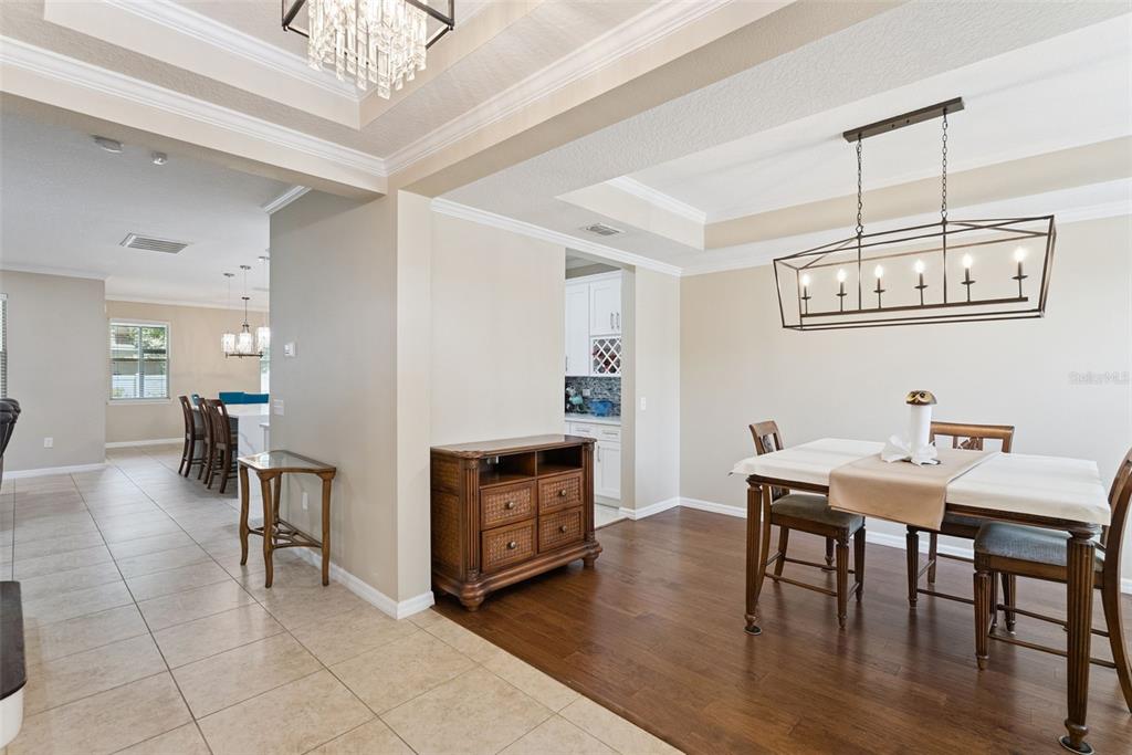 A dining area with hardwood floors, a rectangular chandelier, and a wooden buffet cabinet — 8701 IRON MOUNTAIN TRAIL, WINDERMERE, FL