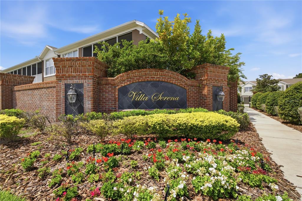 A brick monument sign for Villa Serena sits in front of a landscaped garden — 2111 RIVER TURIA CIRCLE, RIVERVIEW, FL