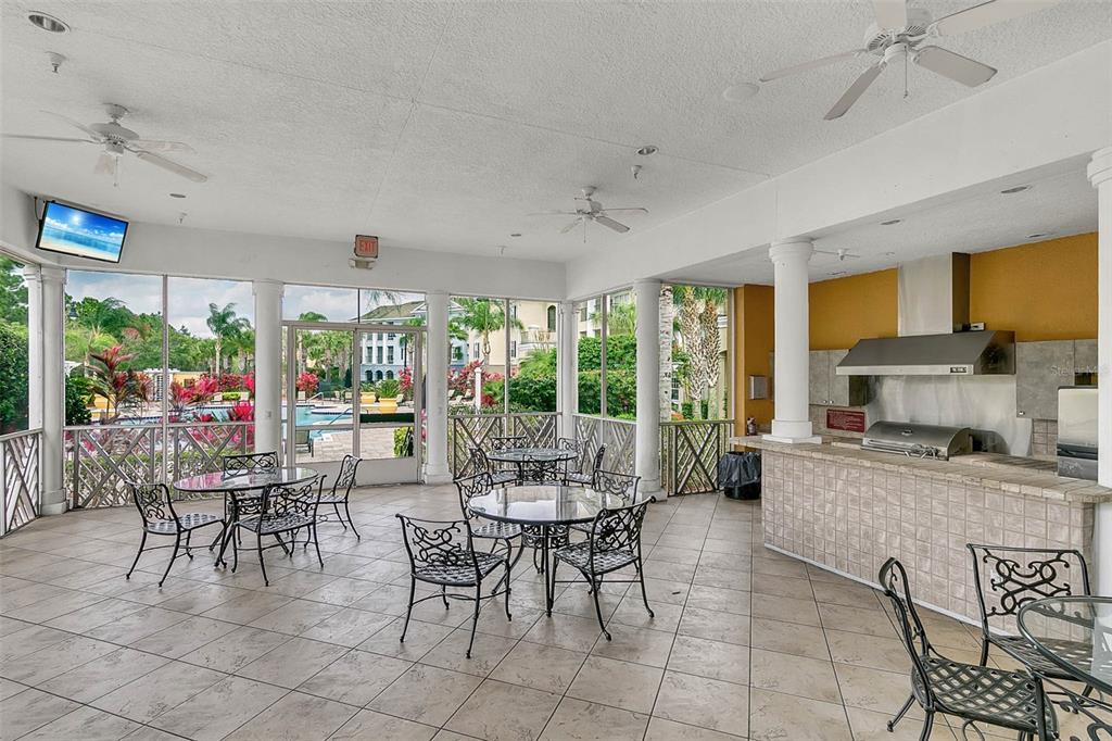 A kitchen features white cabinets, white appliances, a breakfast bar, and tile flooring — 3615 CONROY ROAD UNIT 627, ORLANDO, FL