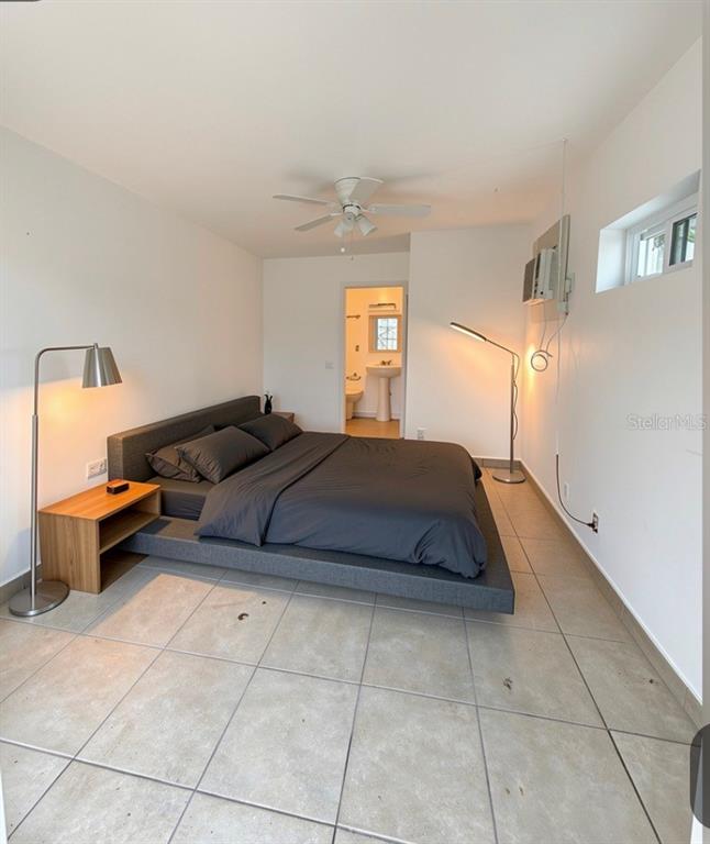 A bedroom features a platform bed, tile flooring, a ceiling fan, and an attached bathroom — 471 HOLT AVENUE, WINTER PARK, FL