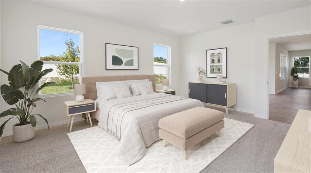 A bedroom features a king-sized bed, a beige bench, and a dark grey console table — 5416 SW 55TH TERRACE, GAINESVILLE, FL