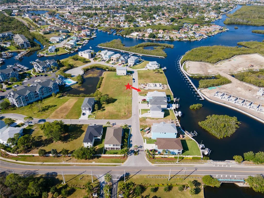An aerial view shows a vacant waterfront lot situated between two houses — Lot 7 ELISABETHAN LANE, NEW PORT RICHEY, FL