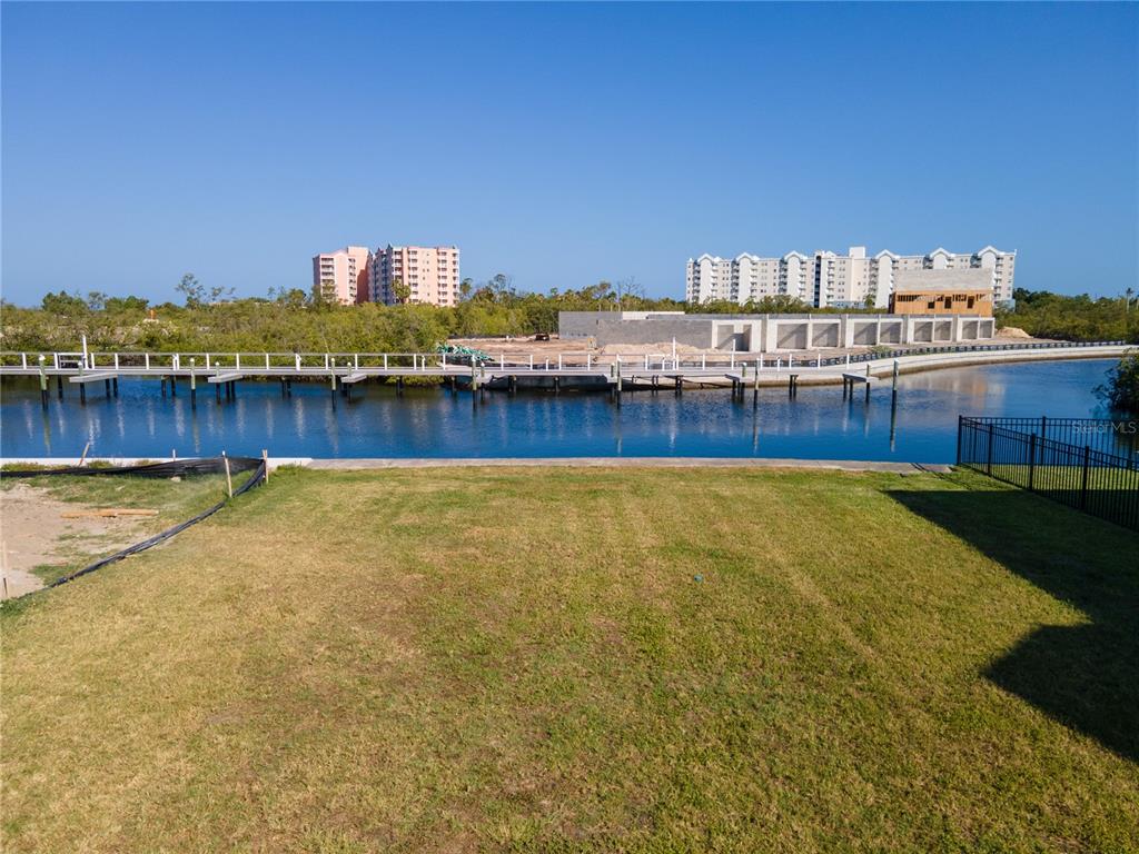 An aerial view shows a vacant, rectangular waterfront lot outlined in red between two houses — Lot 7 ELISABETHAN LANE, NEW PORT RICHEY, FL