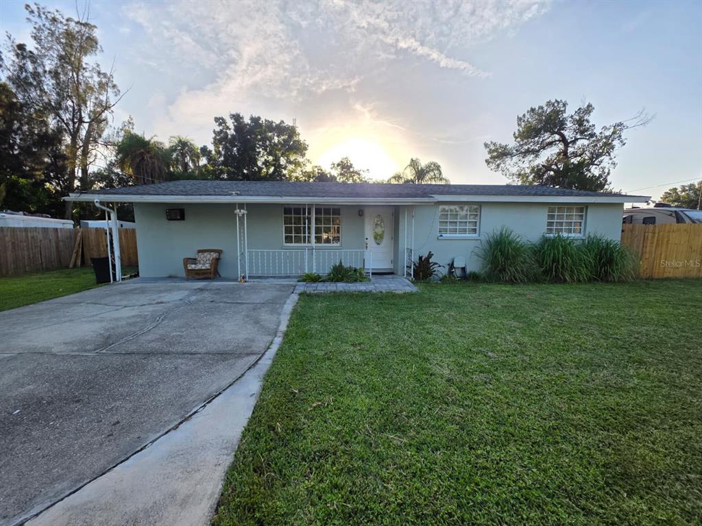 A single-story house with a concrete driveway, a front lawn, and a white front door — 3412 16TH STREET E, BRADENTON, FL