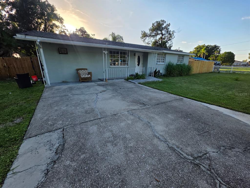 A single-story house features a cracked concrete driveway, a covered porch, and a grassy yard — 3412 16TH STREET E, BRADENTON, FL