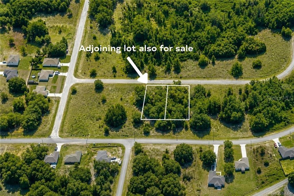 An aerial view shows two adjacent vacant lots outlined in white along a paved road — 7644 N FISHER TERRACE, CITRUS SPRINGS, FL