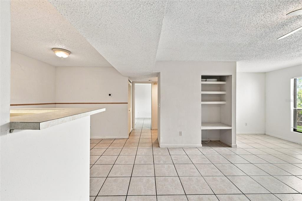 An interior view of a room with white walls, tiled floors, and built-in wall shelving — 455 ALT 19 S UNIT L200, PALM HARBOR, FL