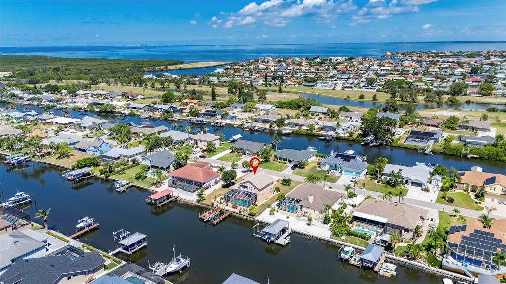 An aerial view shows a waterfront house with a pool cage and private boat dock — 830 GOLF ISLAND DRIVE, APOLLO BEACH, FL