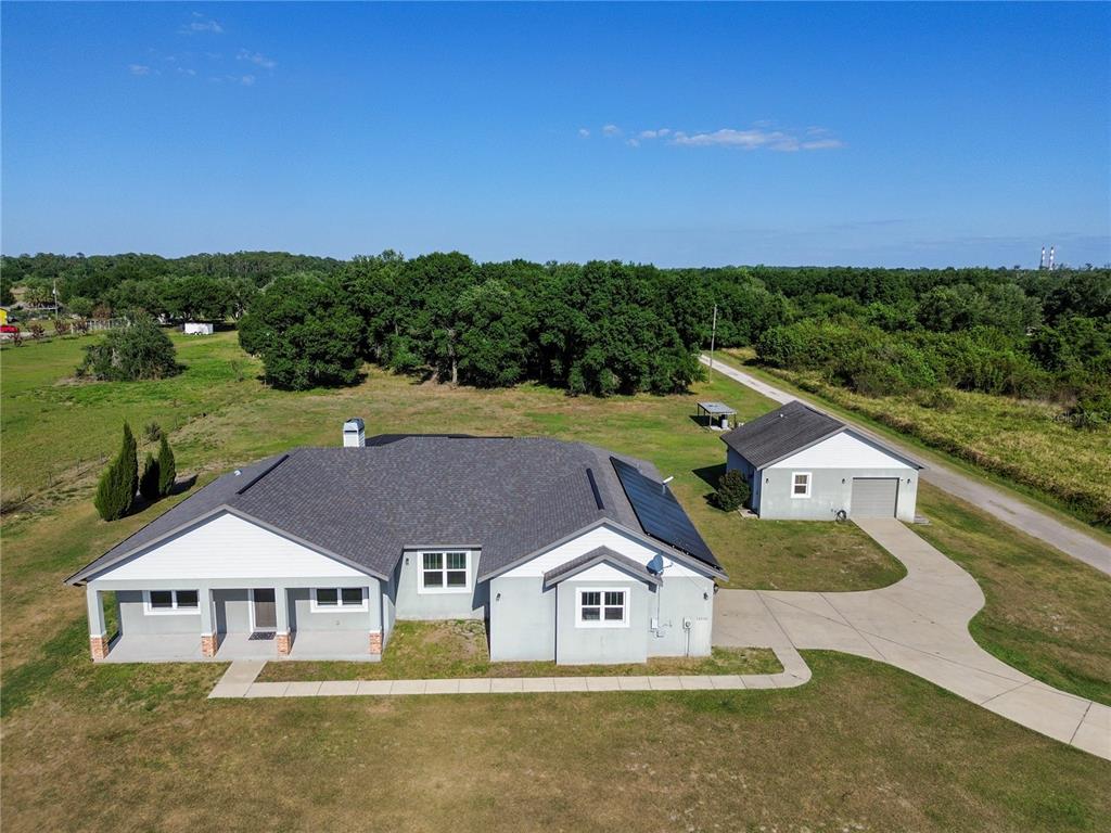 An aerial view shows a single-story house with a detached garage on a grassy lot — 14805 US-301 N, PARRISH, FL