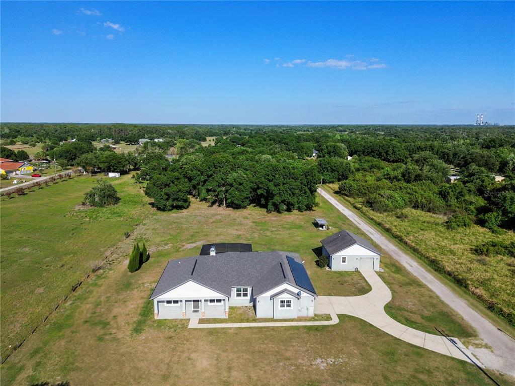 An aerial view shows a house with an attached garage and a separate detached garage — 14805 US-301 N, PARRISH, FL