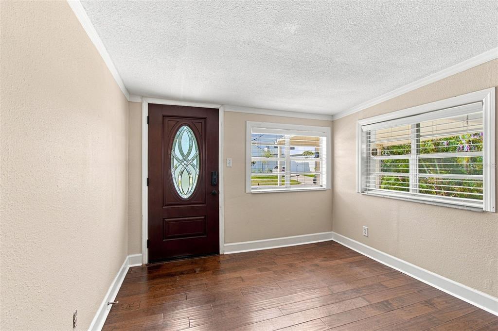 An entryway with a dark wood front door, light walls, and dark wood-look flooring — 805 W BRADDOCK STREET UNIT A, TAMPA, FL