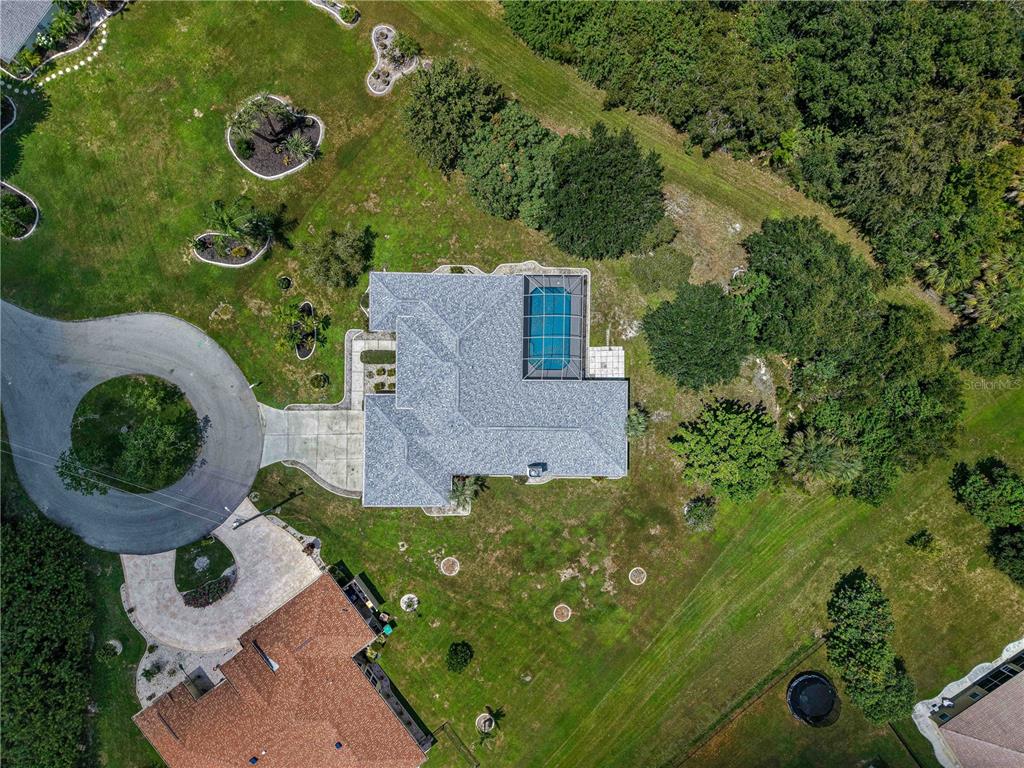 An aerial view shows a house with a screened-in pool and a circular driveway — 27334 ORURO DRIVE, PUNTA GORDA, FL