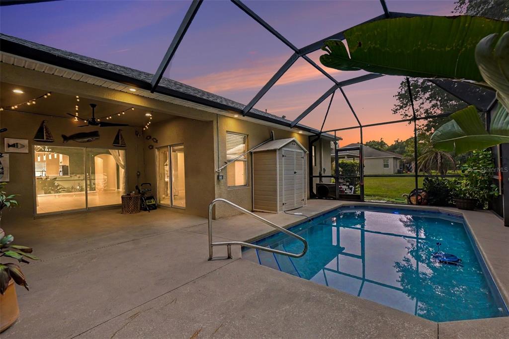 A dining room features a wooden oval table, gray chairs, and a modern pendant light — 7610 TANGLE BROOK BOULEVARD, GIBSONTON, FL