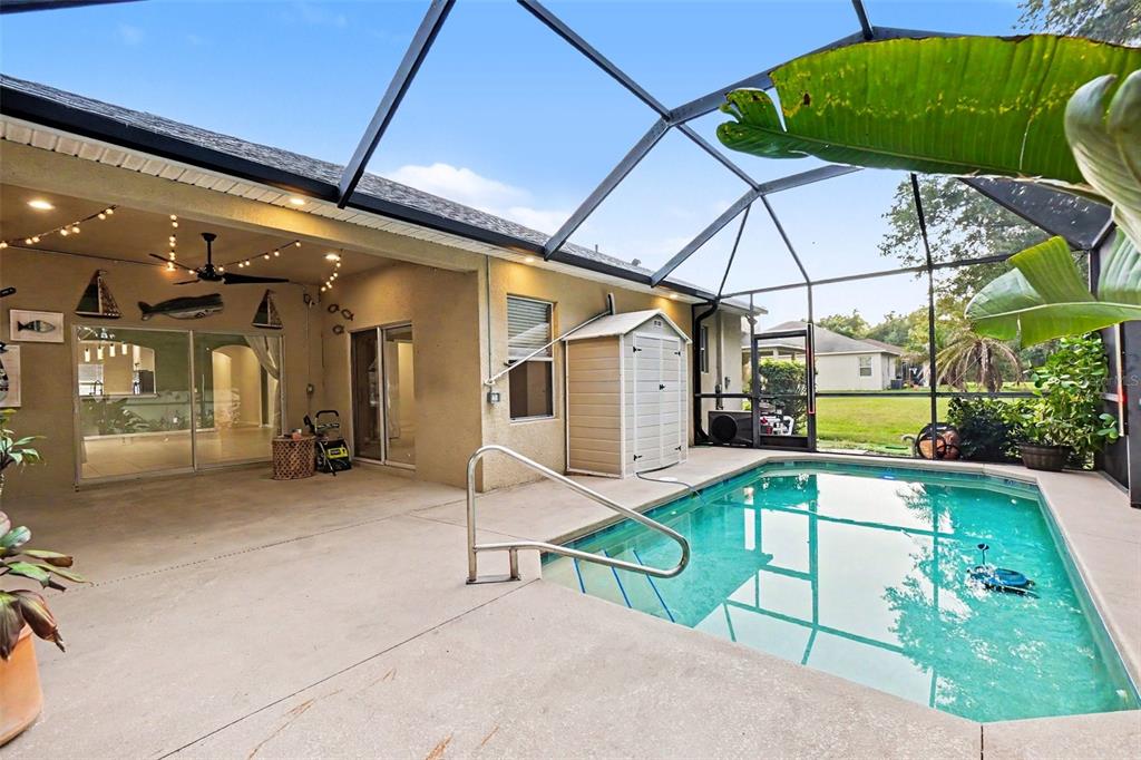 An empty living room features sage green walls, light tile flooring, and arched doorways — 7610 TANGLE BROOK BOULEVARD, GIBSONTON, FL