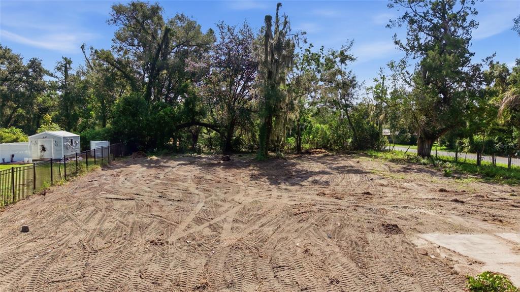 A vacant, cleared dirt lot features tire tracks, surrounding trees, and a small storage shed — 39211 JARVIS STREET, DADE CITY, FL